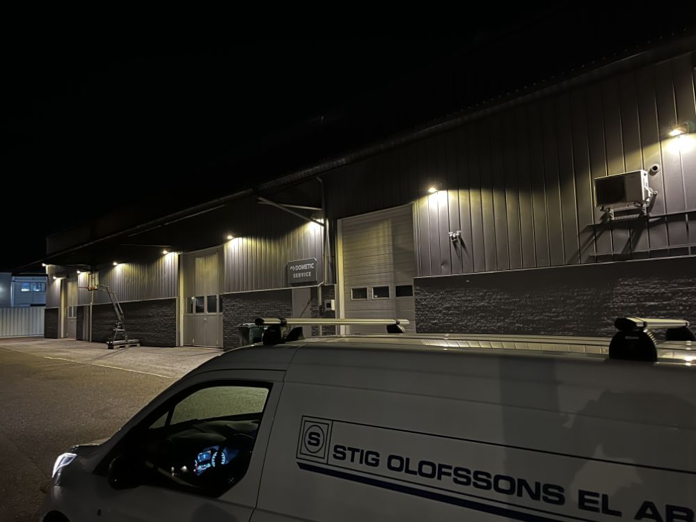 Olofssons EL:s servicebil framför en belyst verksamhetslokal